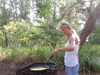 P8230114  Heidi cooking up the eggs and bacon I brought. Poor Heidi was at this for a long time because I didn't realize I should have cooked up the bacon first when the flames were really high. We tossed lighter fluid in to get the coals fired up and it all came out ok :)
