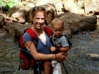 2010-03-23MaunawiliDemoAndFalls (47)  Mom says "Smile, please?" I'm carrying Ben now. Have already almost careened down a slippery slope with him in my arms. I remember doing this hike three years ago and love it for adults. With kids it is a nightmare. The potential for injury is pretty high for all, unless your kid is 5+ years old, strong, and enjoys mud.