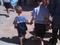 IMAG0308  Leaving church they spontaneously held hands. How nice! They are off to get donuts. Very quick walk to scout them out. Ben has Mr. Purrfect with him in his left hand. A little red cat we found in a geocache several years ago. Mr. Purrfect is supposed to behave well at church. Ben tells him how and takes charge of him.